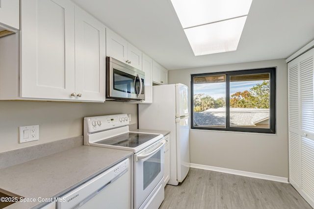 kitchen featuring light wood-type flooring, white appliances, and white cabinetry