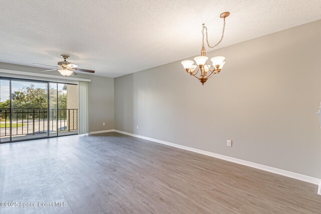 unfurnished room featuring dark hardwood / wood-style flooring, ceiling fan with notable chandelier, and a textured ceiling