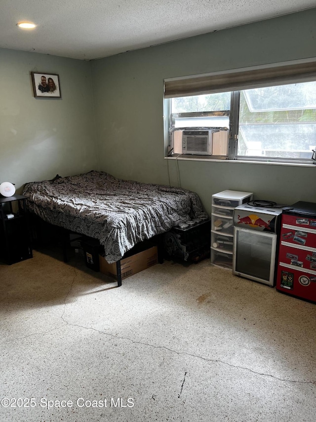 bedroom featuring cooling unit and a textured ceiling