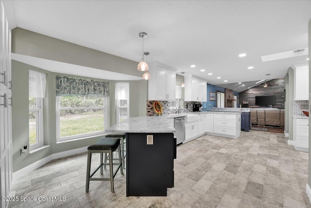 kitchen with white cabinetry, dishwasher, kitchen peninsula, decorative light fixtures, and a kitchen bar