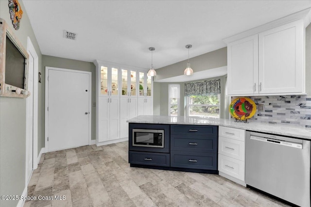 kitchen featuring decorative backsplash, appliances with stainless steel finishes, light stone countertops, white cabinetry, and hanging light fixtures