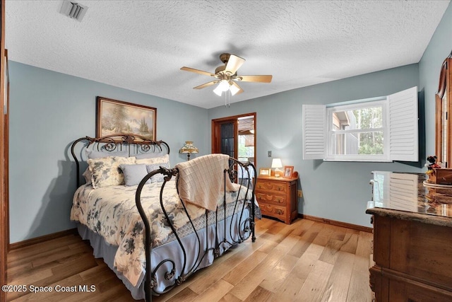 bedroom with a textured ceiling, light wood-type flooring, and ceiling fan