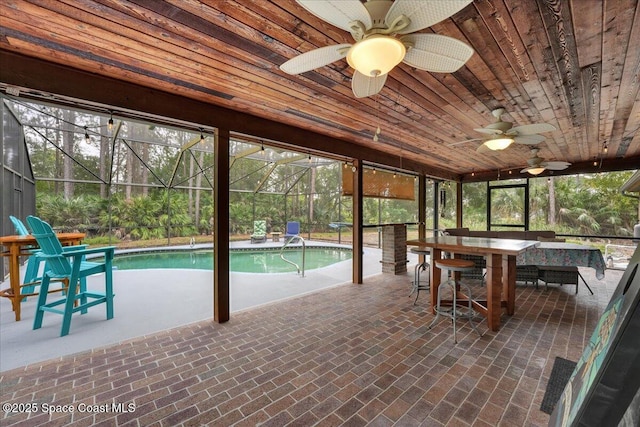 unfurnished sunroom with a wealth of natural light, ceiling fan, wood ceiling, and a pool