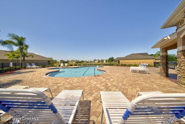 community pool featuring a patio and fence