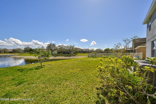 view of yard with a water view and fence