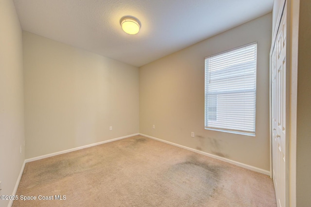 carpeted spare room with baseboards