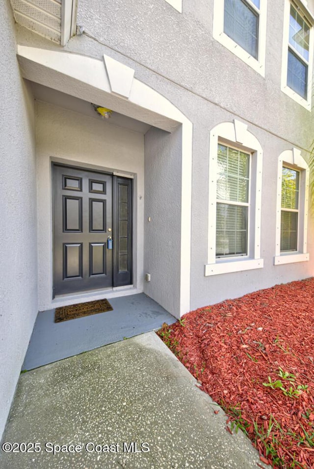 entrance to property with stucco siding