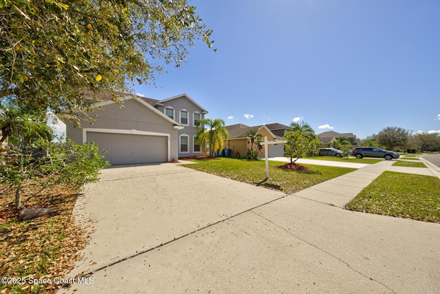 traditional-style house featuring a front yard, concrete driveway, an attached garage, and stucco siding