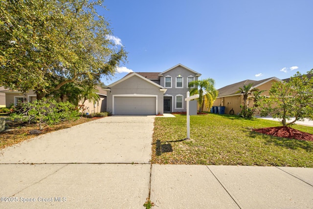 traditional home with a garage, concrete driveway, a front lawn, and stucco siding