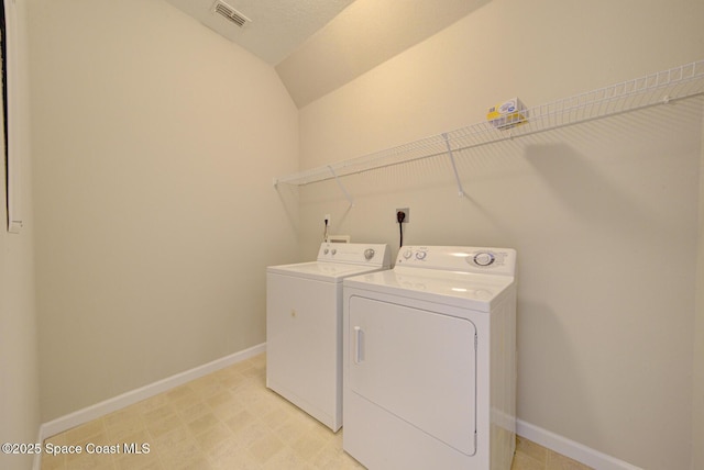 laundry area with laundry area, washing machine and dryer, visible vents, and baseboards