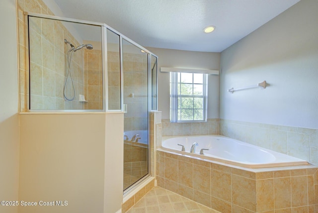 bathroom with a garden tub, a shower stall, and a textured ceiling