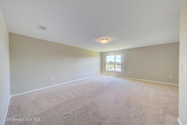 unfurnished room with baseboards, visible vents, a textured ceiling, and carpet flooring