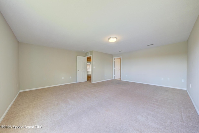 carpeted spare room featuring visible vents and baseboards