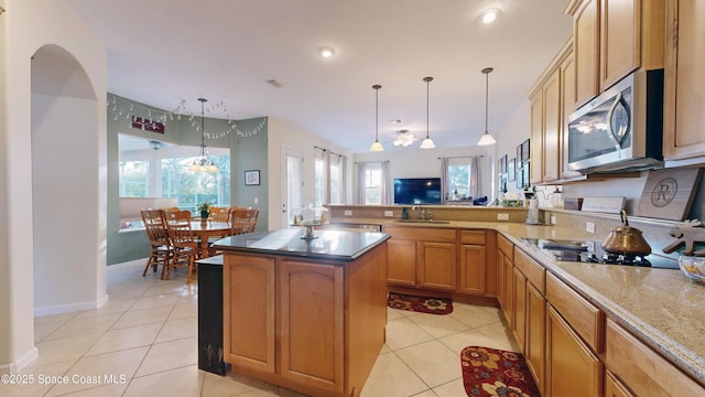 kitchen featuring decorative light fixtures, light tile patterned flooring, kitchen peninsula, and sink