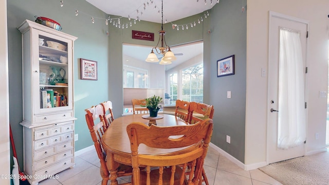 tiled dining area with a chandelier