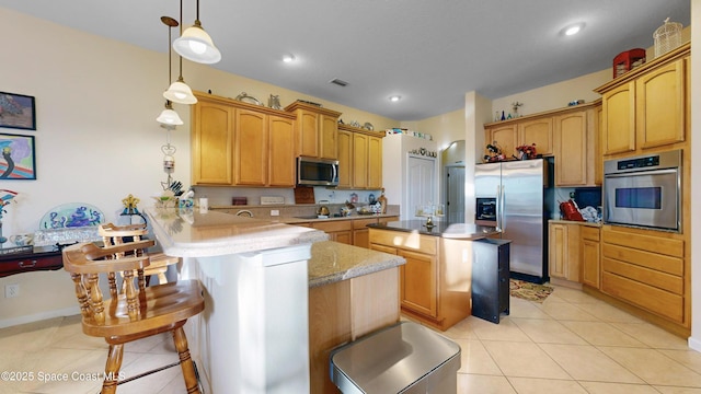 kitchen featuring a breakfast bar, decorative light fixtures, kitchen peninsula, and appliances with stainless steel finishes