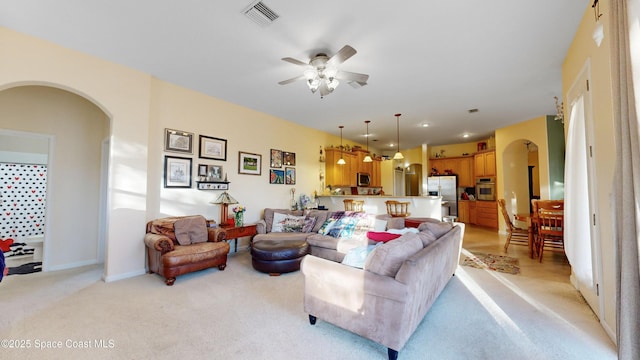 carpeted living room with ceiling fan