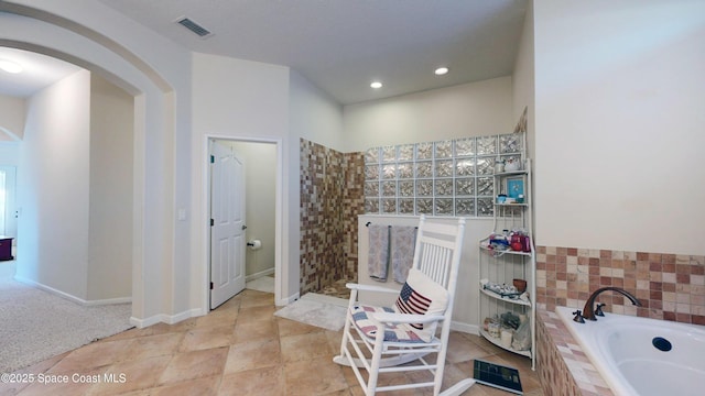 bathroom featuring shower with separate bathtub