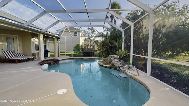 view of pool featuring glass enclosure and a patio area