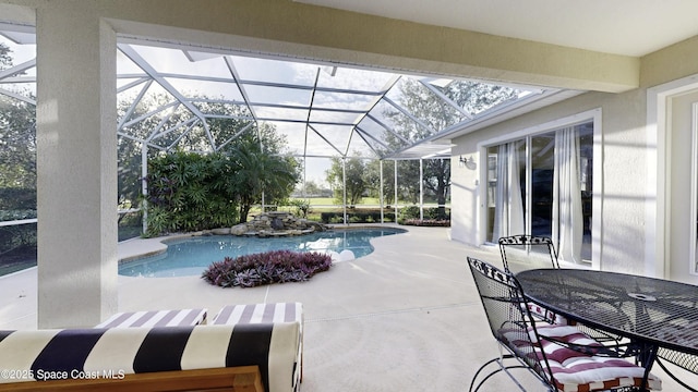 view of pool featuring glass enclosure and a patio area