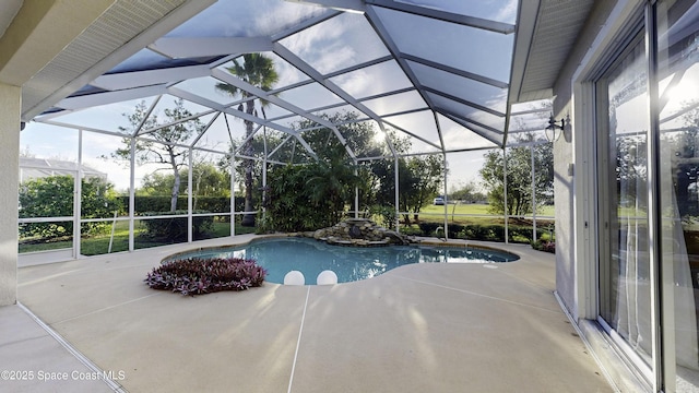 view of swimming pool featuring glass enclosure and a patio