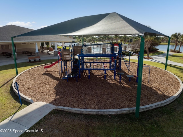 view of jungle gym featuring a lawn and a water view