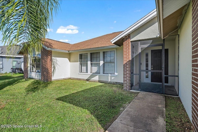 view of exterior entry with a yard