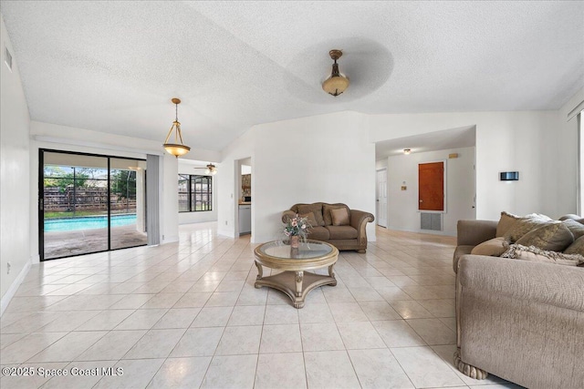 living room featuring ceiling fan, light tile patterned flooring, lofted ceiling, and a textured ceiling