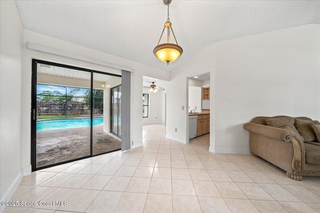 interior space featuring ceiling fan, sink, a textured ceiling, and vaulted ceiling