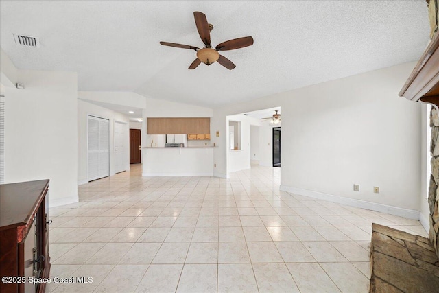 unfurnished living room with a textured ceiling, ceiling fan, lofted ceiling, and light tile patterned flooring