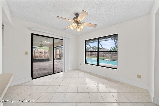 tiled spare room with ceiling fan and a textured ceiling