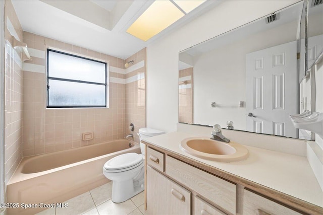 full bathroom featuring tile patterned flooring, vanity, tiled shower / bath combo, and toilet