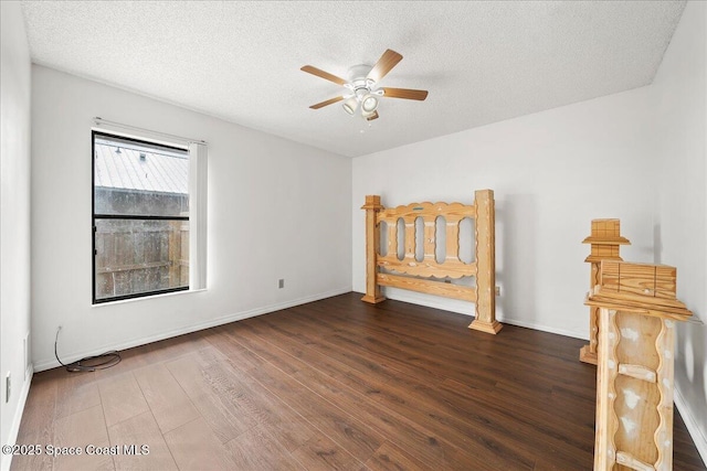 unfurnished bedroom featuring a textured ceiling, ceiling fan, and dark wood-type flooring