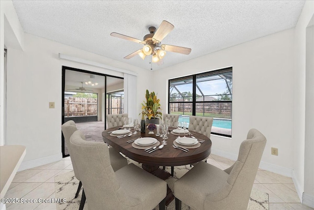tiled dining space with ceiling fan and a textured ceiling