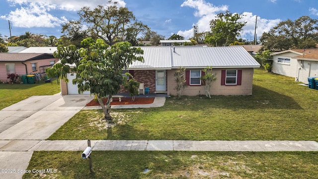 ranch-style home featuring driveway, metal roof, and a front lawn