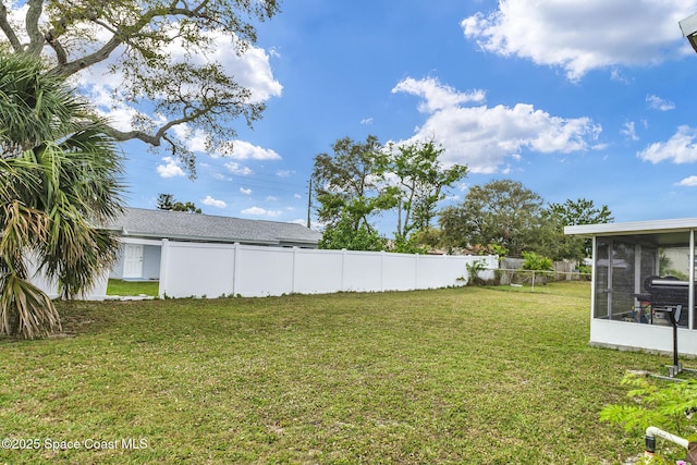 view of yard with a sunroom and a fenced backyard