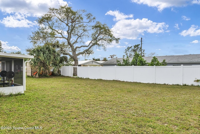 view of yard with a sunroom and a fenced backyard