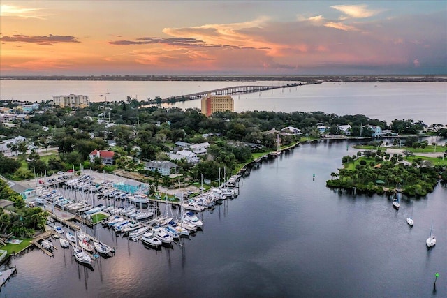 aerial view at dusk featuring a water view