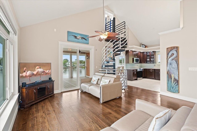 living room featuring a water view, high vaulted ceiling, and wood-type flooring