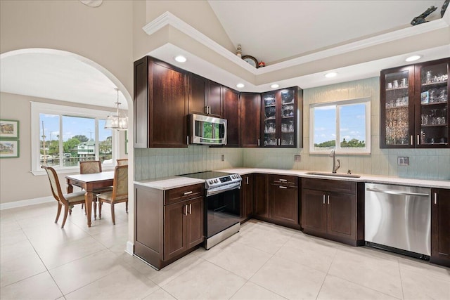 kitchen featuring stainless steel appliances, decorative backsplash, sink, vaulted ceiling, and light tile patterned floors