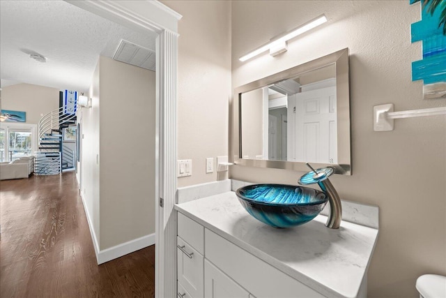 bathroom featuring vanity, a textured ceiling, and wood-type flooring