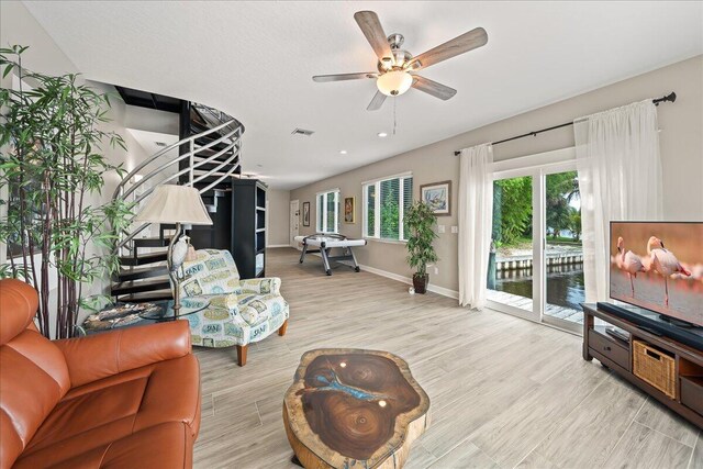 living room with light wood-type flooring and ceiling fan