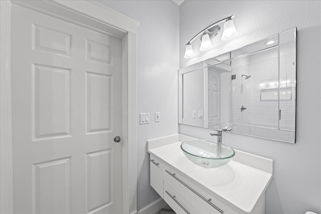 bathroom featuring walk in shower and vanity