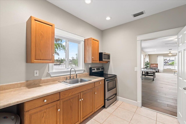 kitchen featuring ceiling fan, sink, light tile patterned floors, and stainless steel appliances