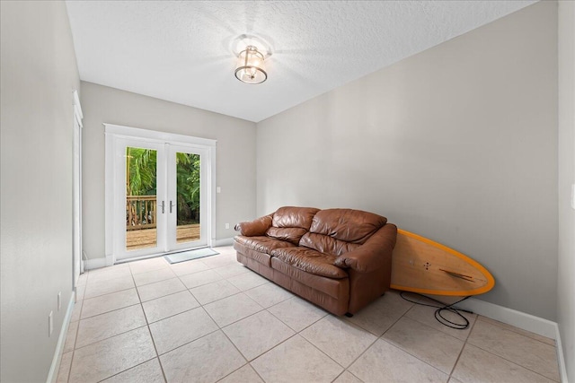 tiled living room with a textured ceiling and french doors