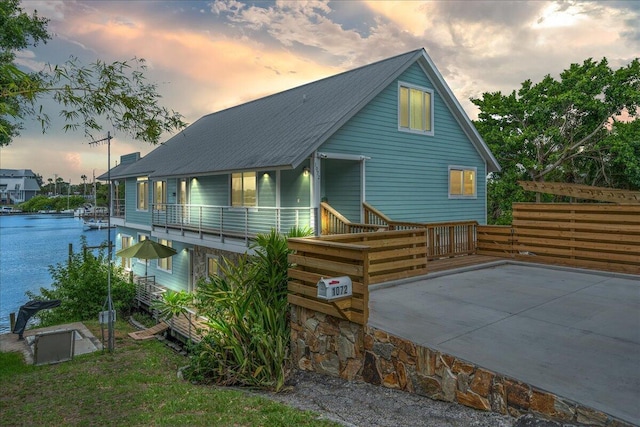 back house at dusk featuring a balcony