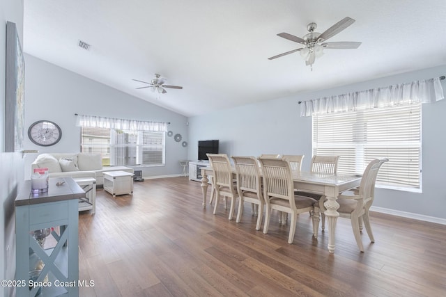 dining space featuring ceiling fan, vaulted ceiling, and hardwood / wood-style flooring