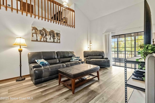 living room featuring hardwood / wood-style flooring and high vaulted ceiling