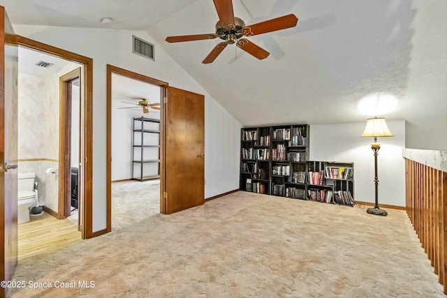 interior space with light carpet and vaulted ceiling