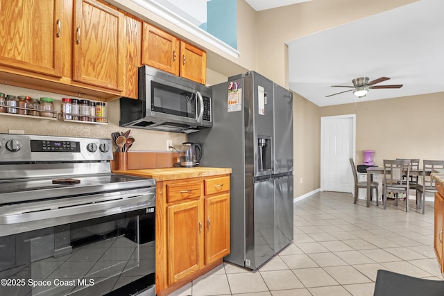 kitchen featuring ceiling fan, light tile patterned flooring, and appliances with stainless steel finishes